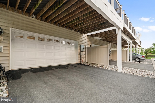 garage featuring asphalt driveway
