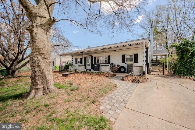 rear view of property with a porch and concrete driveway
