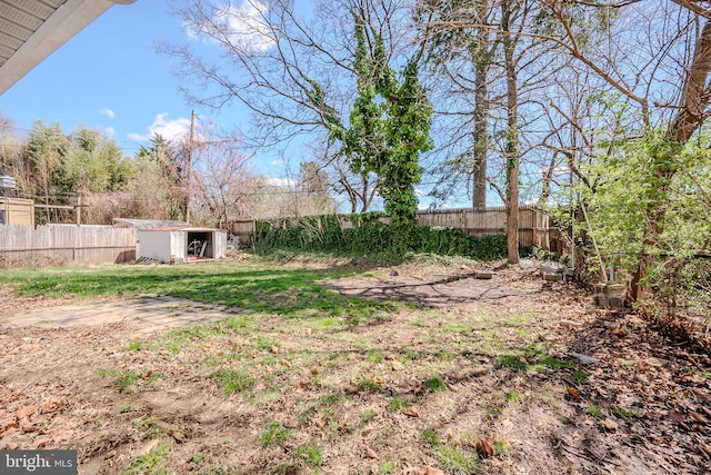 view of yard with a fenced backyard, an outbuilding, and a storage unit