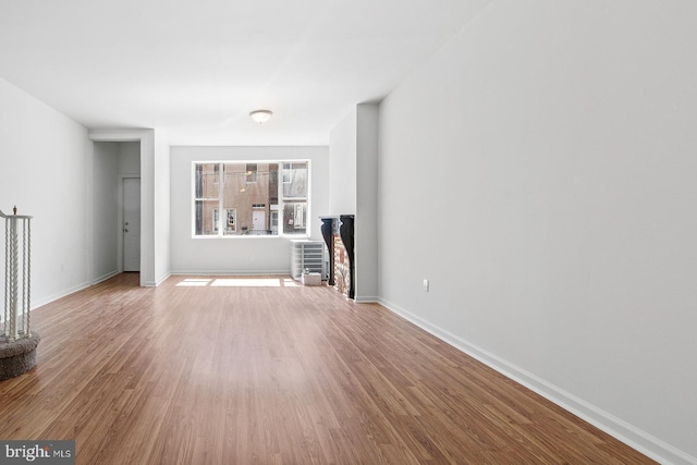 unfurnished living room featuring baseboards and wood finished floors