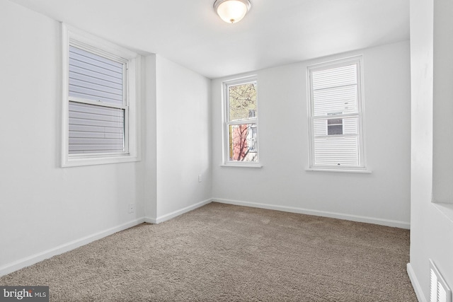 empty room featuring visible vents, baseboards, and carpet flooring