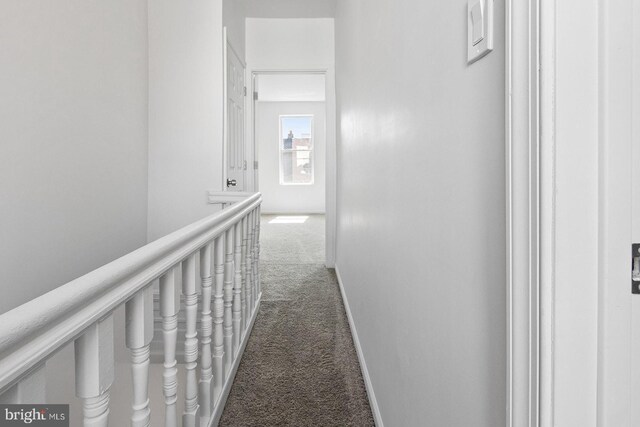 hallway featuring baseboards and carpet