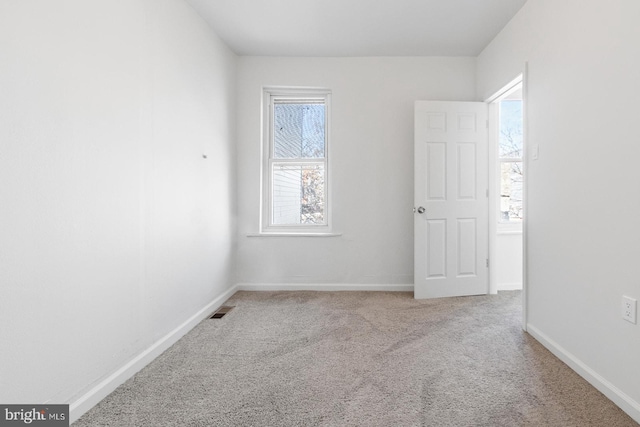 spare room with visible vents, baseboards, and carpet flooring