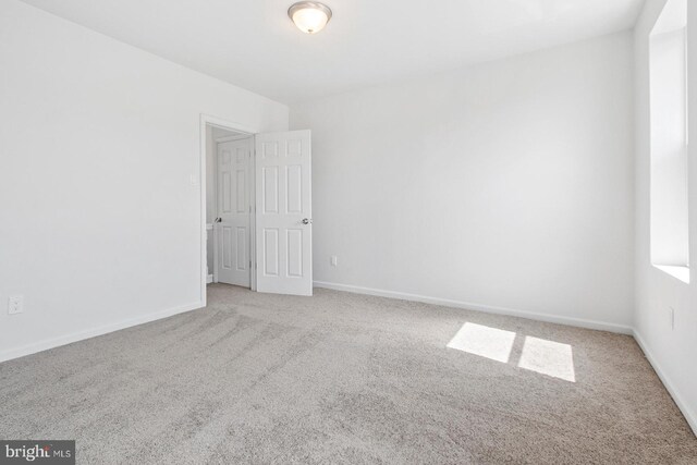 spare room featuring baseboards and carpet flooring
