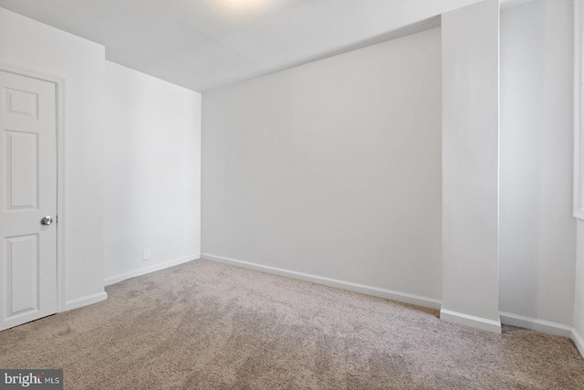 unfurnished room with baseboards and carpet