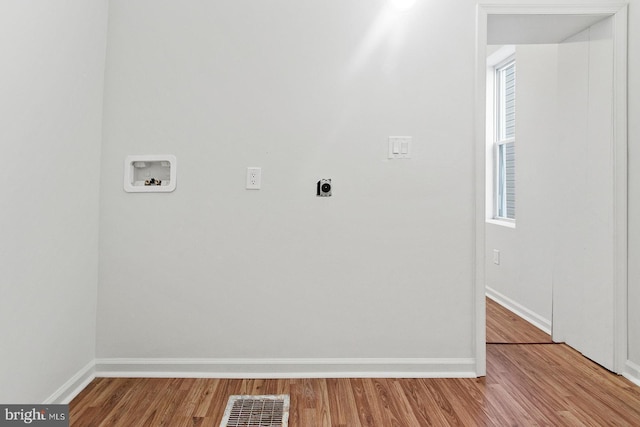 laundry room featuring laundry area, hookup for a washing machine, visible vents, wood finished floors, and baseboards
