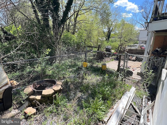 view of yard with an outdoor fire pit and fence