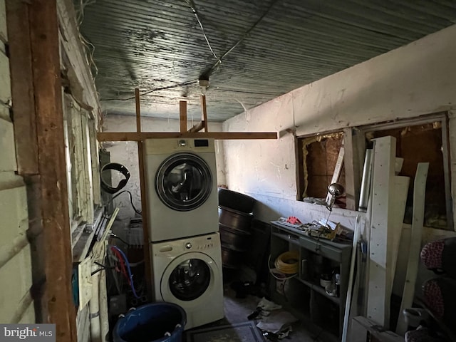 washroom featuring stacked washer / dryer and laundry area