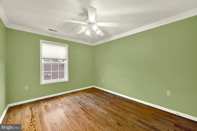 unfurnished room featuring wood finished floors, visible vents, a ceiling fan, crown molding, and baseboards