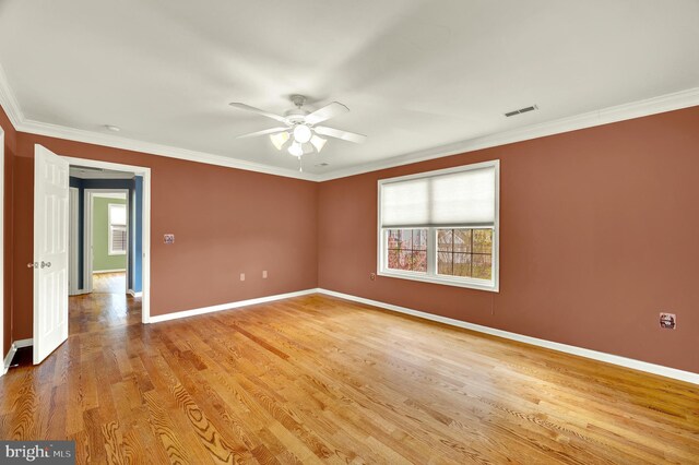 spare room with plenty of natural light, ornamental molding, baseboards, and ceiling fan