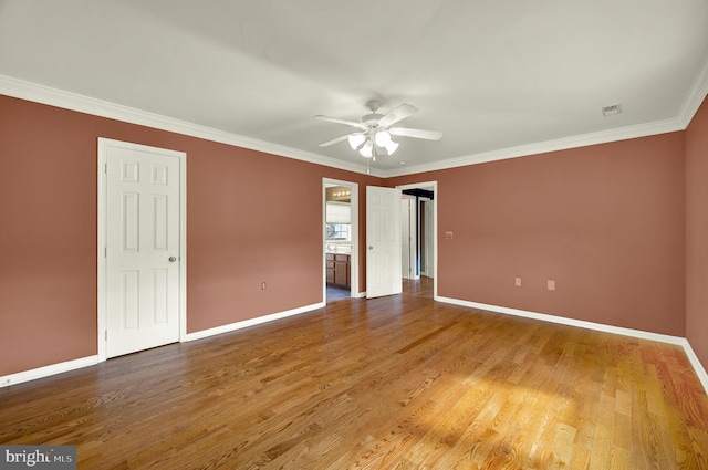 unfurnished bedroom with baseboards, crown molding, and wood finished floors