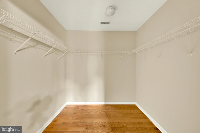 spacious closet featuring visible vents and wood finished floors