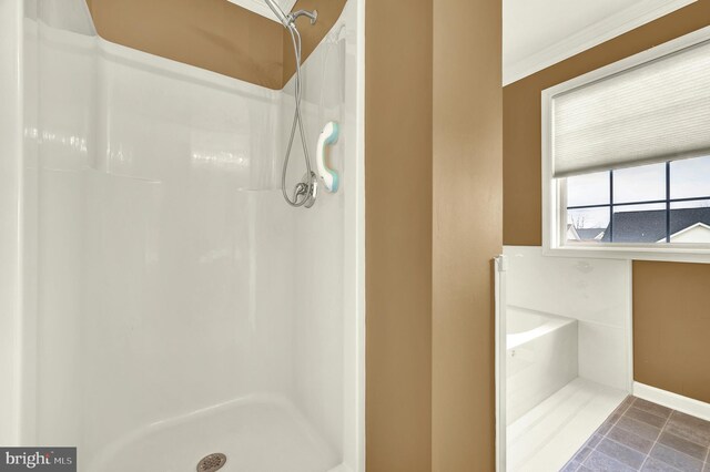 full bathroom with a shower stall, crown molding, and baseboards