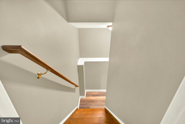 staircase featuring wood finished floors and baseboards