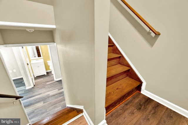 stairway featuring baseboards and wood finished floors