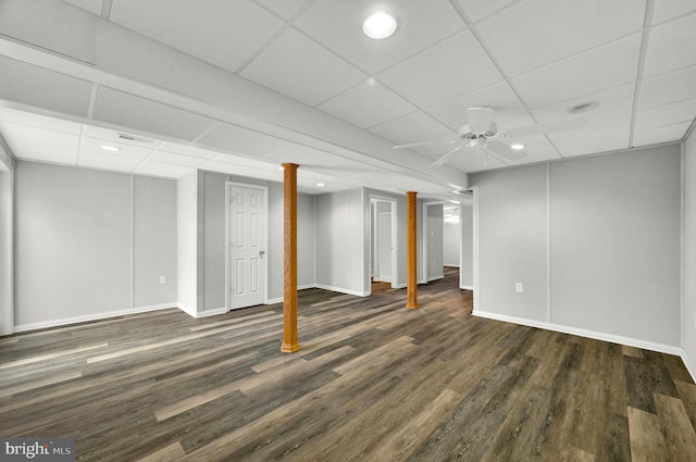 finished basement featuring visible vents, baseboards, a paneled ceiling, and wood finished floors