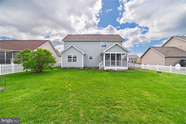rear view of property featuring a fenced backyard, a sunroom, and a yard