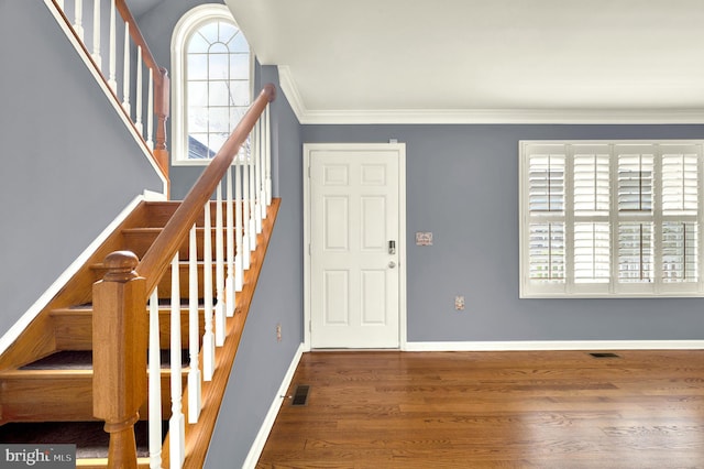 entrance foyer with plenty of natural light, visible vents, stairs, and wood finished floors