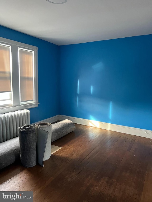 interior space featuring baseboards, radiator heating unit, and hardwood / wood-style floors