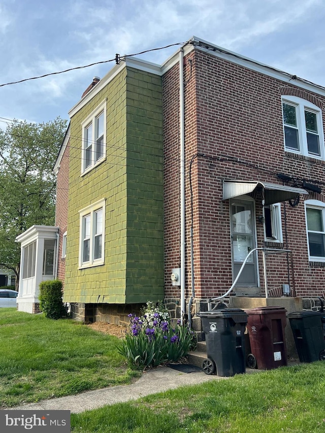 view of side of property featuring a yard and brick siding