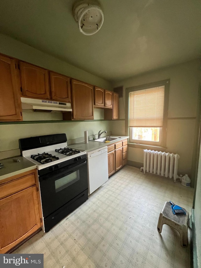 kitchen with black gas range, radiator, under cabinet range hood, a sink, and dishwasher