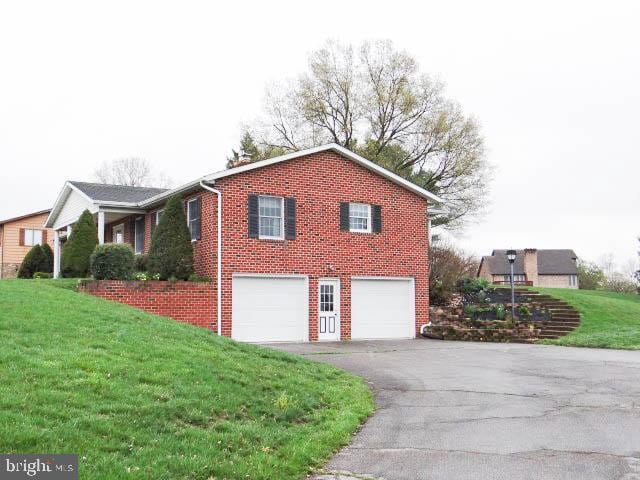 2560 Sardonyx Dr, Chambersburg, PA 17202 - view of home's exterior featuring an attached garage, a yard, aphalt driveway, and brick siding