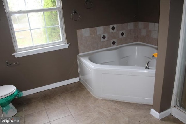 full bath featuring tile patterned floors, a garden tub, and baseboards