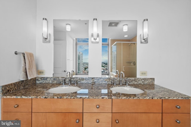 full bath featuring a stall shower and double vanity