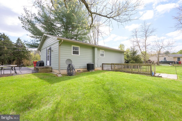 rear view of property with central AC and a lawn