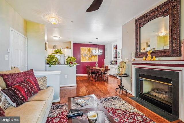 4129 Fountainside Ln Unit 202, Fairfax, VA 22030 - living room featuring wood finished floors, a chandelier, a ceiling fan, a fireplace with flush hearth, and baseboards