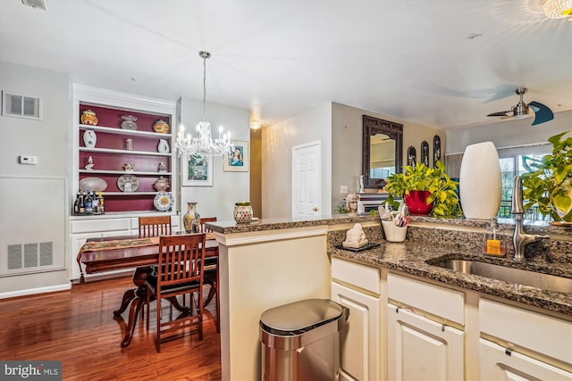 4129 Fountainside Ln Unit 202, Fairfax, VA 22030 - kitchen featuring a sink, a chandelier, wood finished floors, dark stone countertops, and decorative light fixtures