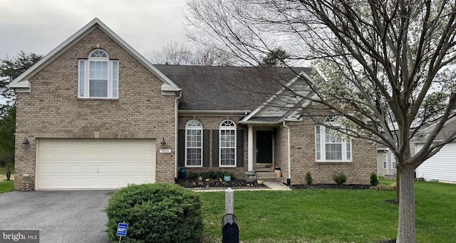 traditional home with aphalt driveway, a shingled roof, a front lawn, an attached garage, and brick siding