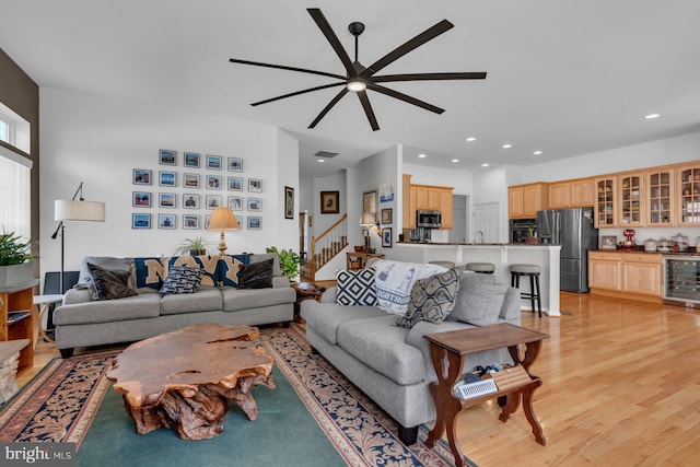 living room featuring recessed lighting, beverage cooler, light wood-style floors, stairs, and ceiling fan
