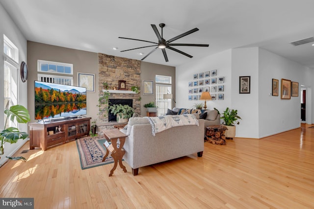 living area with wood finished floors, ceiling fan, a fireplace, visible vents, and recessed lighting
