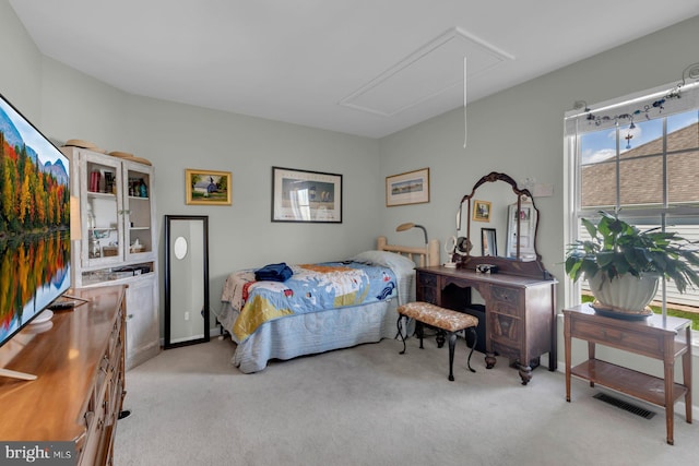 bedroom featuring attic access, light colored carpet, and multiple windows
