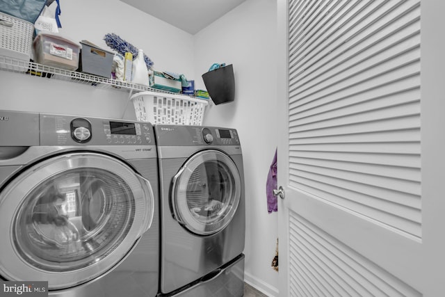 laundry room featuring washing machine and dryer, baseboards, and laundry area