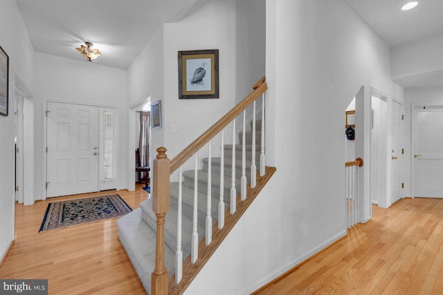 entryway with baseboards, wood finished floors, and stairway