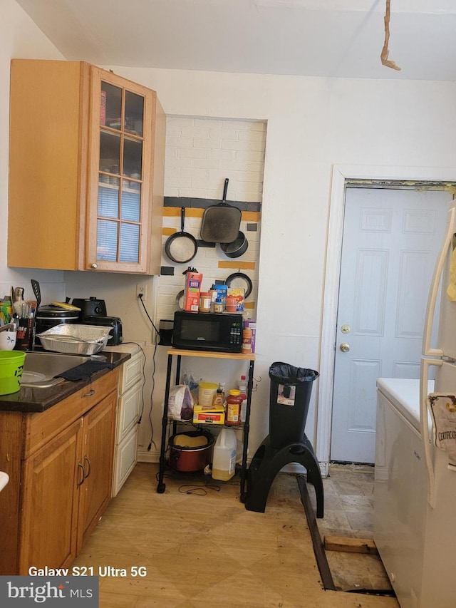 2538 N Myrtlewood St, Philadelphia, PA 19132 - kitchen with dark countertops, glass insert cabinets, washer / dryer, and black microwave