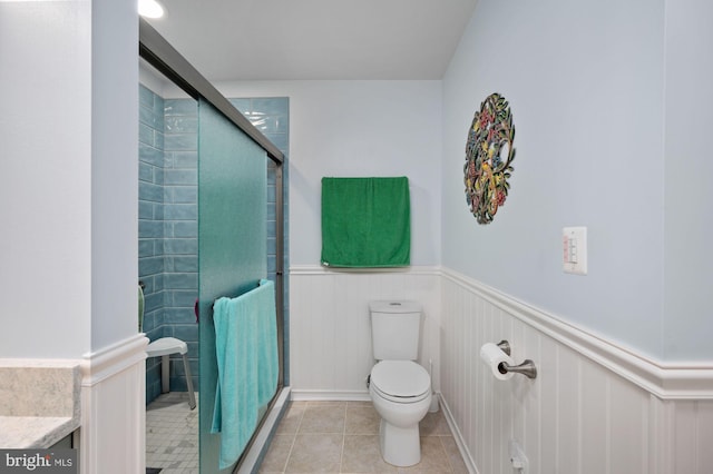 135 Cleremont Dr, Fredericksburg, VA 22405 - bathroom featuring toilet, a shower stall, tile patterned flooring, and a wainscoted wall