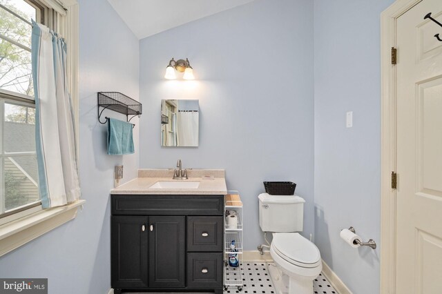 135 Cleremont Dr, Fredericksburg, VA 22405 - bathroom with baseboards, toilet, vanity, vaulted ceiling, and tile patterned floors