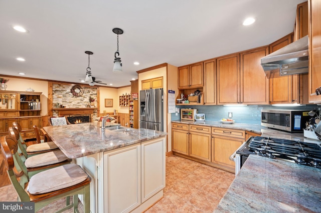 135 Cleremont Dr, Fredericksburg, VA 22405 - kitchen featuring tasteful backsplash, a stone fireplace, light stone counters, exhaust hood, and appliances with stainless steel finishes