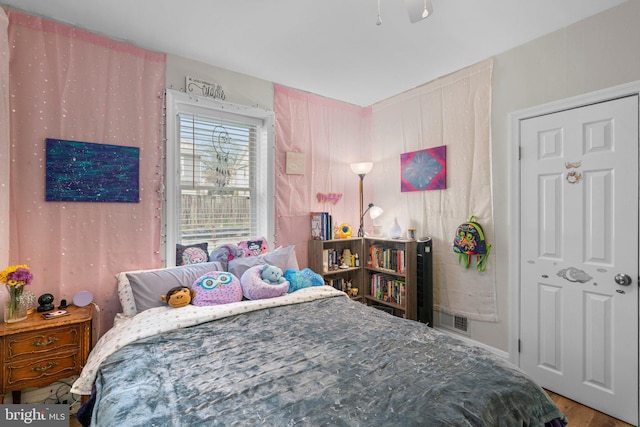 bedroom featuring visible vents and wood finished floors