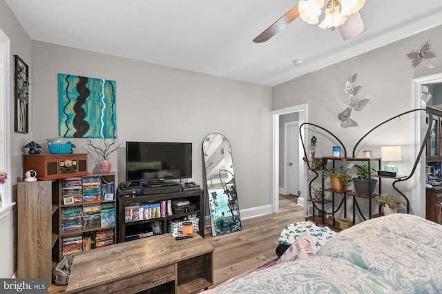 living area featuring baseboards, wood finished floors, and ceiling fan