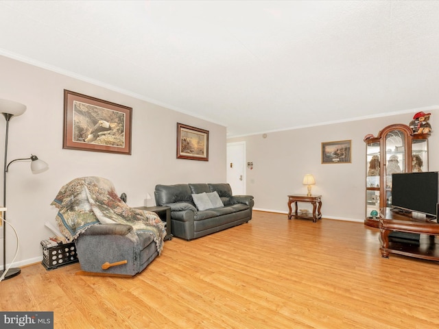 living room with baseboards, crown molding, and wood finished floors