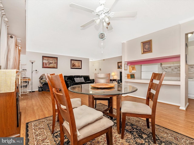 dining area featuring light wood-style floors, baseboards, and a ceiling fan