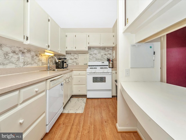 kitchen featuring white appliances, light countertops, white cabinetry, decorative backsplash, and a sink