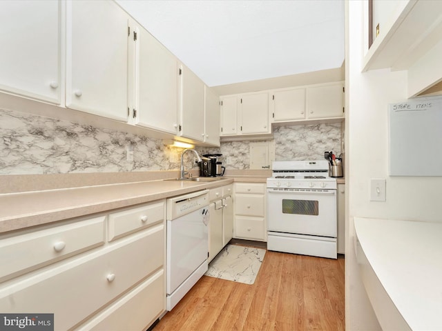 kitchen featuring white appliances, light countertops, a sink, and backsplash