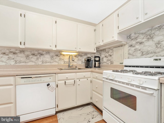 kitchen with light countertops, tasteful backsplash, a sink, and white appliances