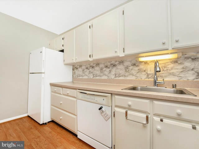kitchen with light wood-style floors, white appliances, light countertops, a sink, and backsplash