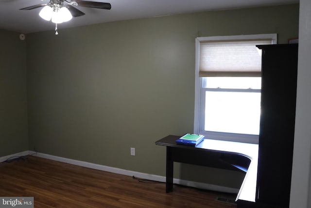 spare room featuring wood finished floors, visible vents, a ceiling fan, and baseboards